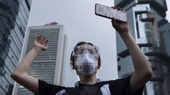 Протестующий держит мобильный телефон