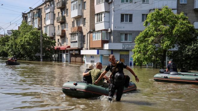 Polícia evacua residentes locais de uma área inundada após o rompimento da barragem de Nova Kakhovka