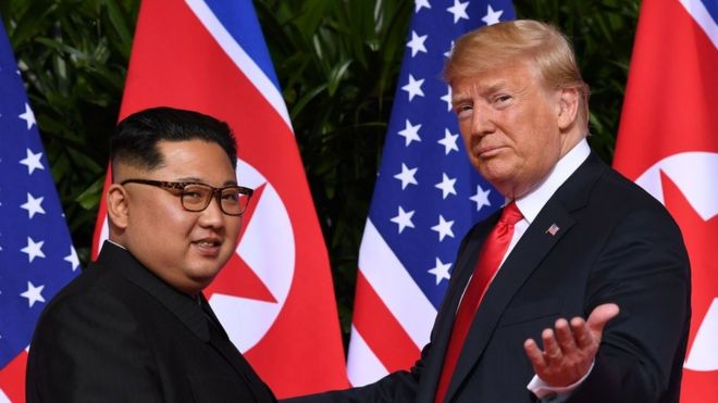 Дональд Трамп (справа) показывает, как он встречается с лидером Северной Кореи Ким Чен Ыном (слева)