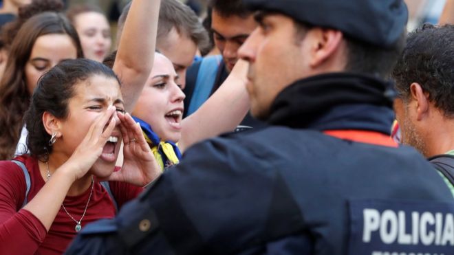 Женщина выкрикивает лозунги против испанской национальной полиции во время митинга в Барселоне, 2 октября 17