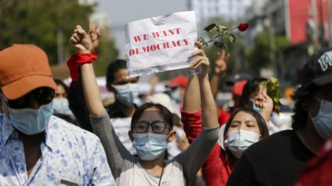 A demonstrator holds up a placard reading "We Want Democracy" during a protest against the military coup in Yangon, Myanmar, 7 February 2021