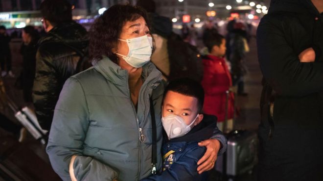 A Chinese boy hugs a relative as she leaves to board a train at Beijing Railway station before the annual Spring Festival