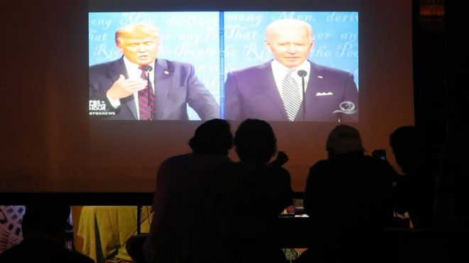 Люди в баре Майами смотрят, как Дональд Трамп и Джо Байден участвуют в их первых дебатах по предвыборной кампании 2020 года