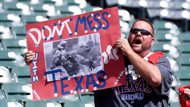 Hombre sostiene un cartel que dice "Don't Mess with Texas" antes del partido entre Toronto Blue Jays at Globe Life Park en Arlington.