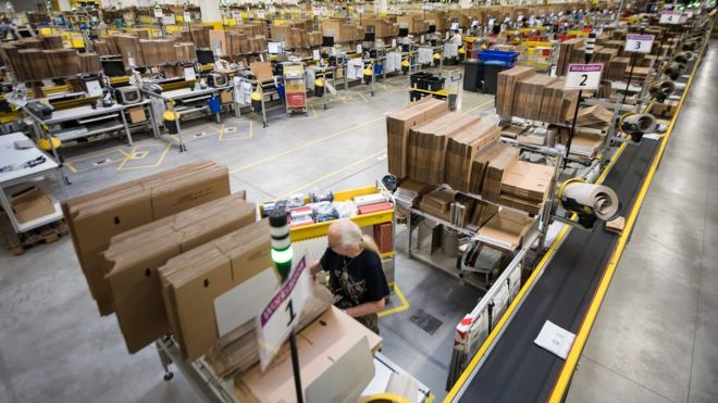 Сотрудники американской компании электронной коммерции Amazon готовят товары для отправки в Бад-Херсфельд, Центральная Германия, 7 декабря 2017 года.