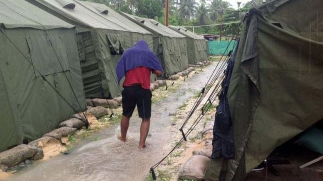 An asylum seeker walks between tents at Australia's detention centre on Manus Island, Papua New Guinea