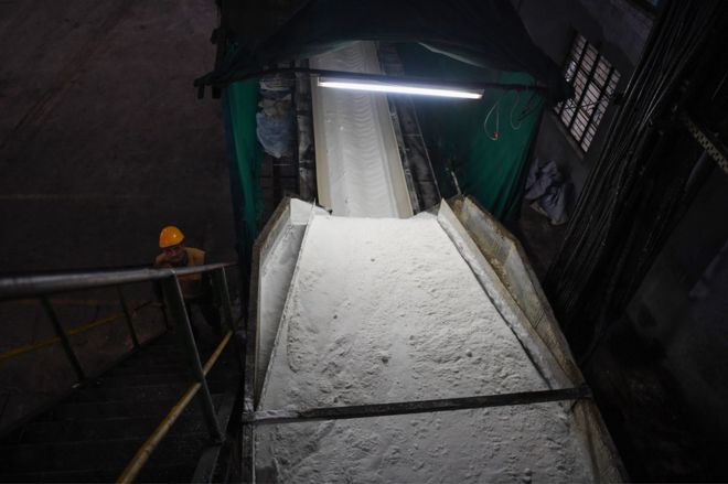 Индийский рабочий изображен рядом с заводом по переработке сахарного тростника на сахарном заводе Тривени в деревне Сабитгарх в округе Буландшахр в северном штате Уттар-Прадеш.