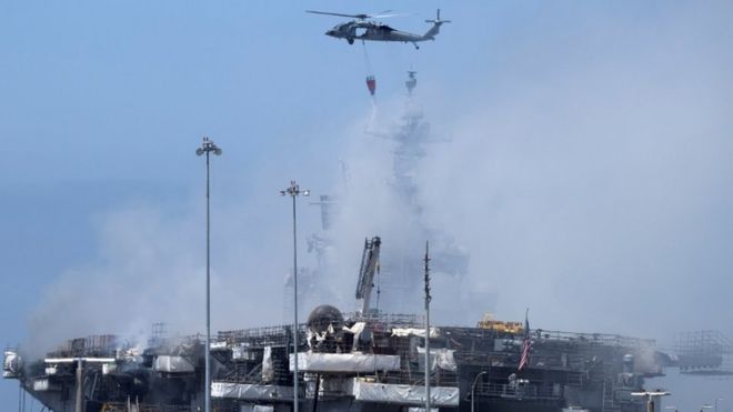 Вертолет ВМС США продолжает тушить пожар на десантном корабле USS Bonhomme Richard на военно-морской базе Сан-Диего, в Сан-Диего, штат Калифорния, США, 13 июля 2020 г.