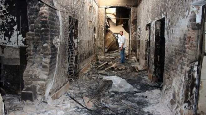 An employee of Doctors Without Borders stands inside the charred remains of their hospital after it was hit by a US airstrike in Kunduz