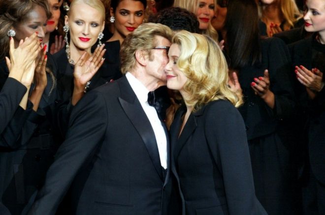 Ив Сен-Лоран (слева) целует Кэтрин Денев в 2002 году во время его последнего показа мод