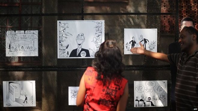 Люди посещают открытую выставку редакционных карикатур и карикатур на президента США Барака Обаму в Найроби, Кения