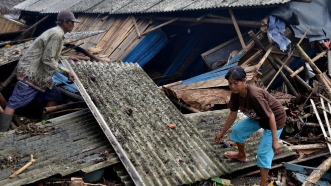 Warga yang rumahnya roboh dihantam tsunami mengambil atap untuk dipasang lagi di Kampung Sinar Laut, Kecamatan Panimbang, Pandeglang, Banten, Minggu (23/12)