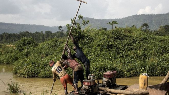 Группа Галамсиеров, незаконных торговцев золотом, использует моторизованный насос для очистки русла реки, когда они ищут пятнышко золота в районе Киби, южная Гана, 12 апреля 2017 года.