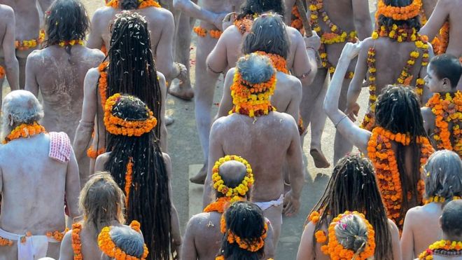 Aghoris indo em grupo para tomar um banho ritualÃ­stico durante festival