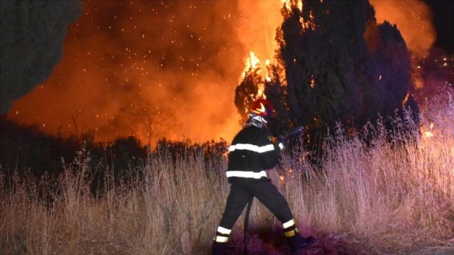A firefighter battles the flames after a wildfire broke out in Petralia Soprana, Italy, 10 August 2021