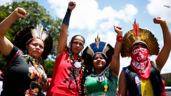 Four indigenous women raise their hands as they call for gender equality during a protest in Brasilia on International Women's Day, on March 8, 2020.