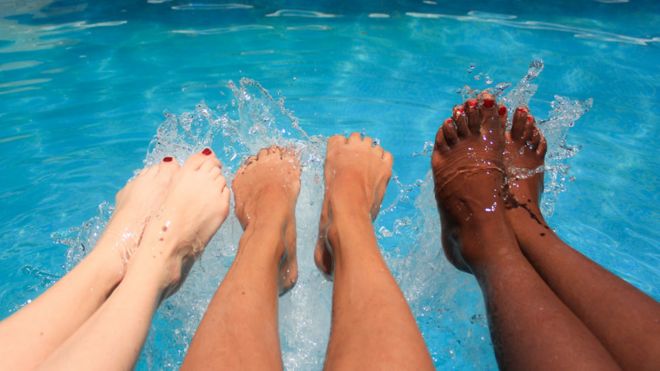 Pies de tres mujeres en una pileta