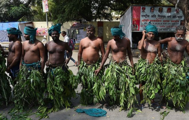 Индийские фермеры из южного штата Тамилнад надевают листья деревьев, участвуя в акции протеста в Дели