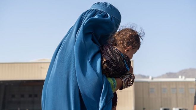 أفغانية تحمل طفلها قرب المطار