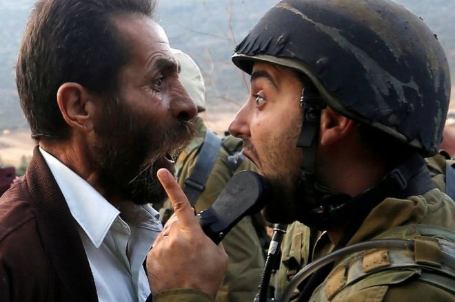 رجل فلسطيني يتجادل مع جندي إسرائيلي