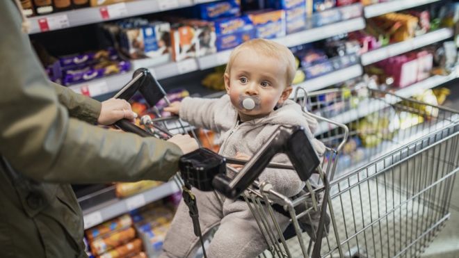 Малыш в тележке в супермаркете