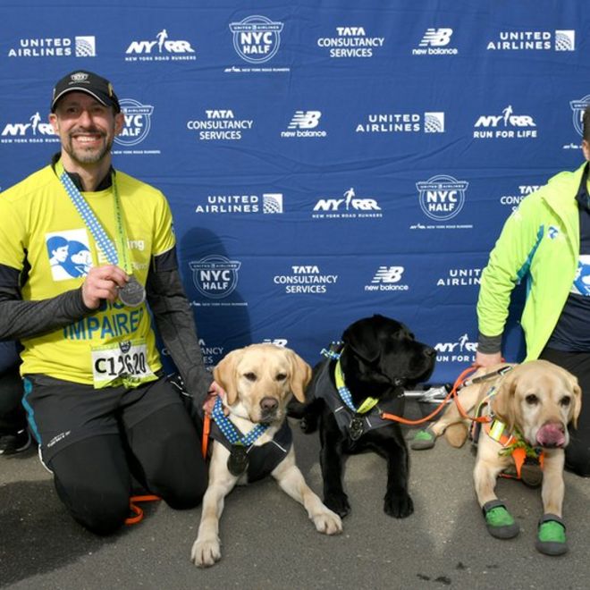 Томас Панек после пробежки полумарафона в Нью-Йорке со своими собаками-поводырями