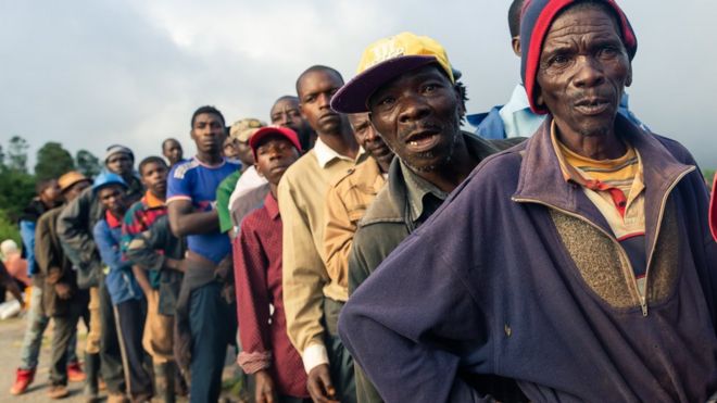 Люди в очереди за раздаточными материалами в Зимбабве