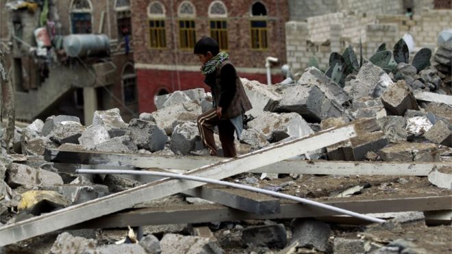 Йеменский ребенок осматривает завалы дома