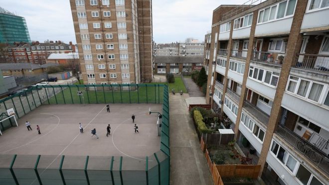 Дети играют в футбол перед жилым комплексом в лондонском районе Тауэр Хэмлетс