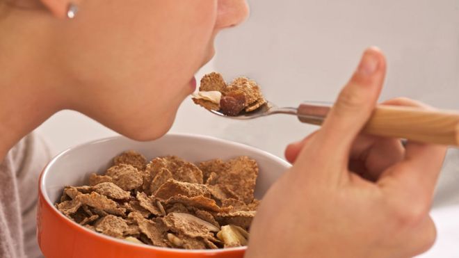 Mujer comiendo cereal.