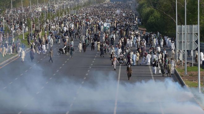Сторонники казненного исламиста Мумтаза Кадри идут по слезоточивому газу, выпущенному полицейскими