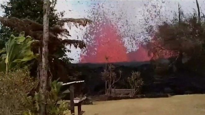 Lava encendida haciendo erupción en el jardín de una casa en Hawái
