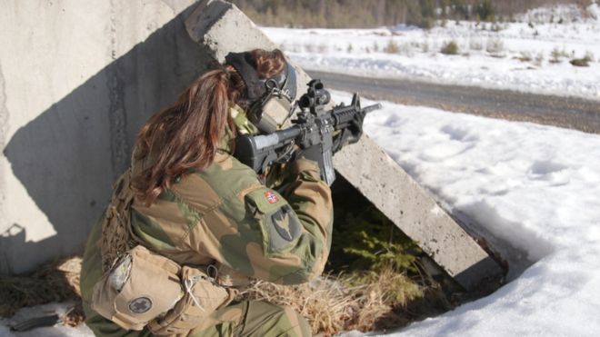 Женщина-солдат стреляет из пистолета