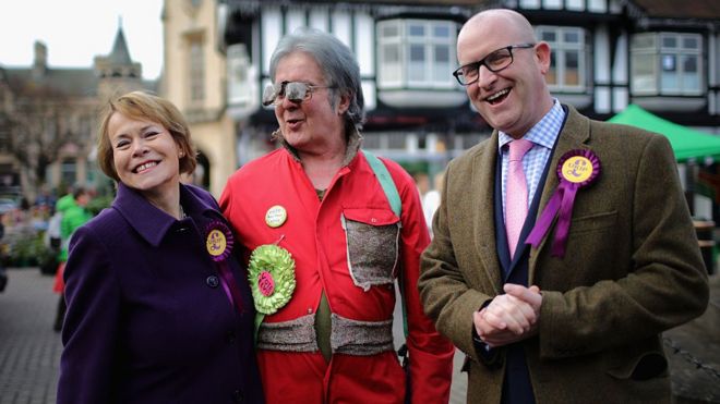 Виктория Эйлинг из UKIP и лидер партии UKIP Пол Наттолл исполняют серенаду Дэвида Бишопа (C), кандидата от партии Bus-Pass Элвис, 3 декабря 2016 года в Слифорде, Англия.