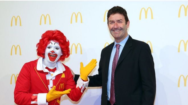 Стив Истербрук, генеральный директор McDonald, позирует с Рональдом Макдональдом во время открытия нового флагманского ресторана McDonald's в терминале 2 международного аэропорта Франкфурта 30 марта 2015 года во Франкфурте-на-Майне, Германия. (