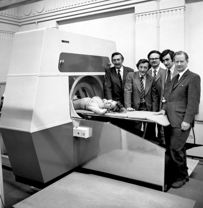 Модель Джиллиан Даксбери вместе с Годфри Хаунсфилдом и другими разработчиками демонстрирует компьютерную томографию