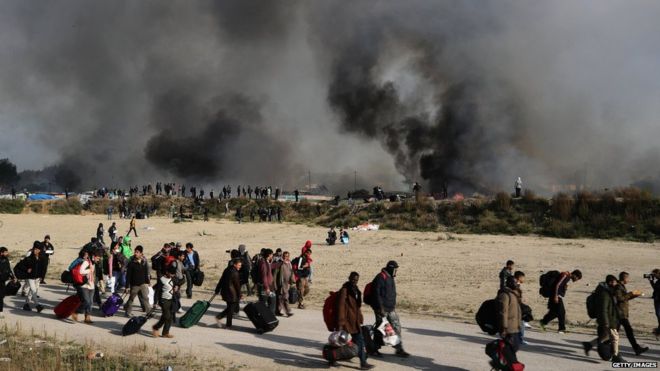 В лагере Джунглей вспыхнул пожар, когда мигранты готовятся к отъезду, в то время как 26 октября 2016 года в Кале, Франция, власти начинают сносить это место.