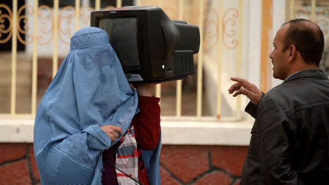 Афганская женщина продает телевизор в Мазари-Шарифе