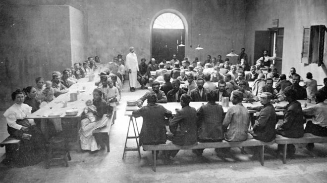 Inmigrantes comiendo en uno de los pabellones de la Isla de Flores.