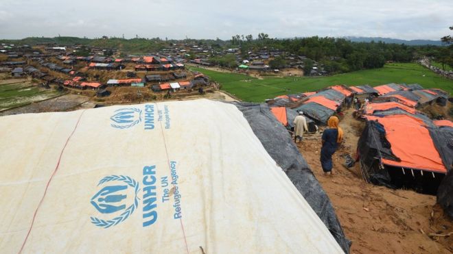A Rohingya Muslim refugee walks through UNHCR tents at a refugee camp near the Bangladesh town of Gumdhum on September 17, 2017