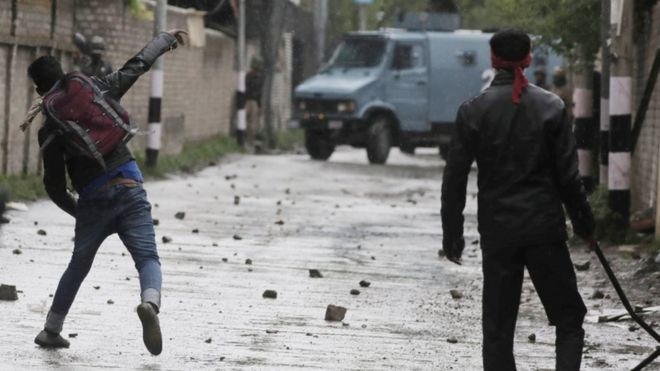 Кашмирский студент бросает камень в полицию во время столкновений у здания Кашмирского политехнического колледжа в Сринагаре, 29 апреля 2017 года