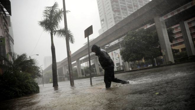A man wades across a flooded street in Miami, Florida, 10 September