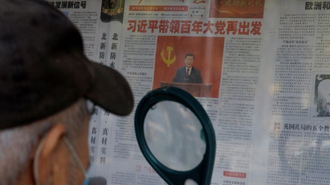 A man reads a newspaper covering the 20th National Congress of the Communist Party of China at a public display stand in Beijing, China October 24, 2022