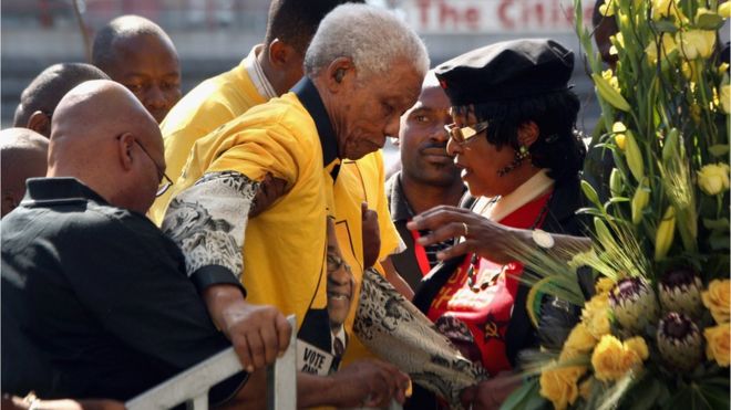 Бывшему президенту Южной Африки Нельсону Манделе, 90 лет, на сцену помогают фаворит президента АНК Джейкоб Зума (слева) и бывшая жена Манделы Винни Мандела (справа), 19 апреля 2009 года в Йоханнесбурге, Южная Африка.