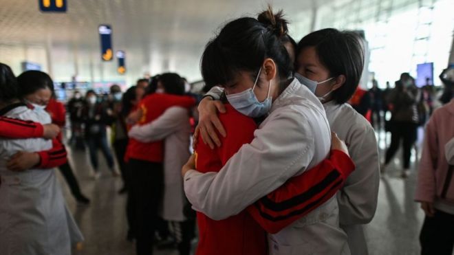Medical staff from Jilin Province (in red) hug nurses from Wuhan after the Covid-19 lockdown was lifted, 8 April 2020