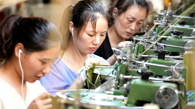 На этом снимке, сделанном 13 августа 2018 года, показаны сотрудники, работающие на производственной линии одежды для экспорта на фабрике в округе Сиай, в Шанцю, в центральной провинции Китая Хэнань. -