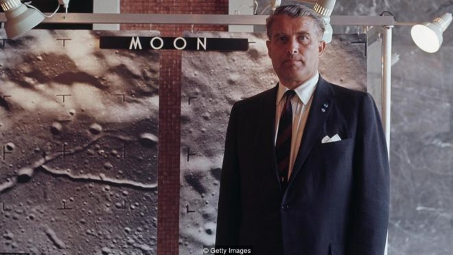 Wernher von Braun posa para foto em frente a painel mostrando a superfície lunar