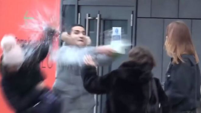 Кадр из видео, где Арья Мосалла проливает жидкость на женщин. Мосалла говорит, что его трюк не был похож на настоящую кислотную атаку