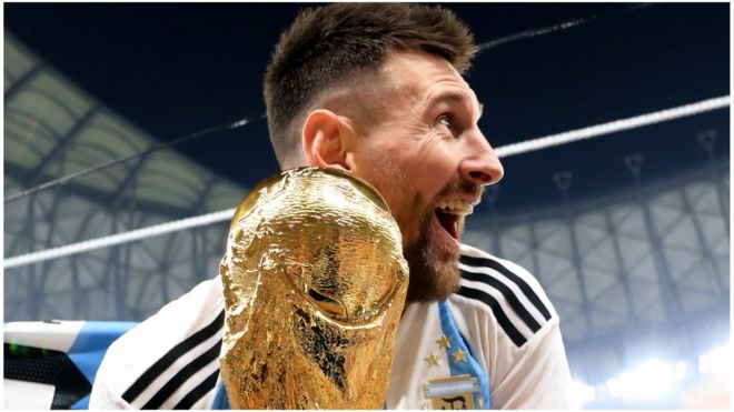 Lionel Messi holds World Cup trophy.