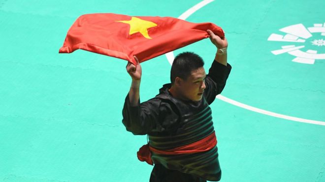 Pesilat Vietnam Van Tri Nguyen membawa bendera usai mengalahkan pesilat Malaysia Moh Khaizul Yaacob dalam babak final Kelas J Putra Asian Games 2018 di Padepokan Pencak Silat Taman Mini Indonesia Indah (TMII), Jakarta, Rabu (29/8).